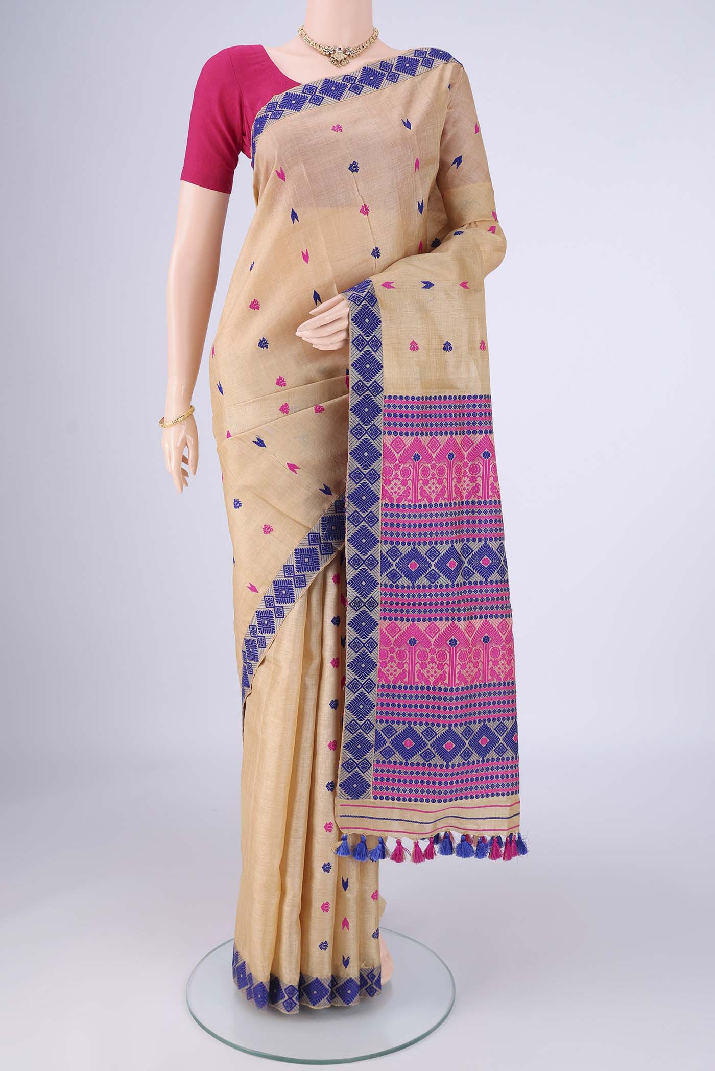 Beige Assam Silk Saree with Thread Butta on the body and Thread Border.  displayed on a mannequin