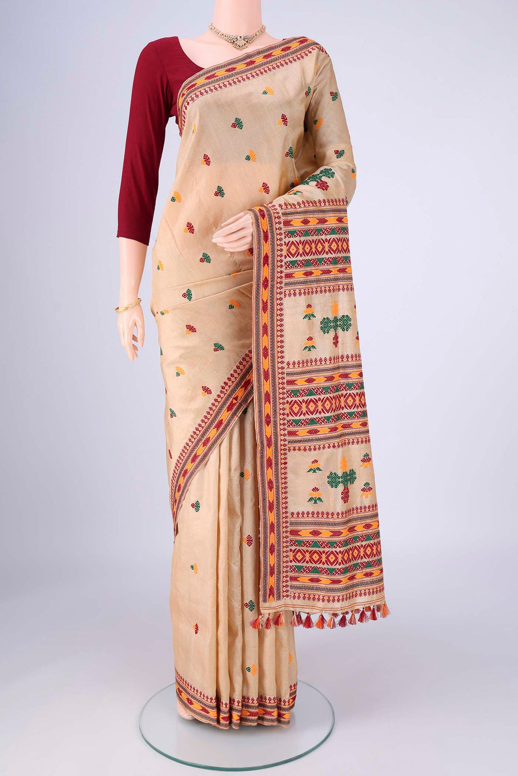 Beige Assam Silk Saree with Thread Butta on the body and Thread Border.  displayed on a mannequin