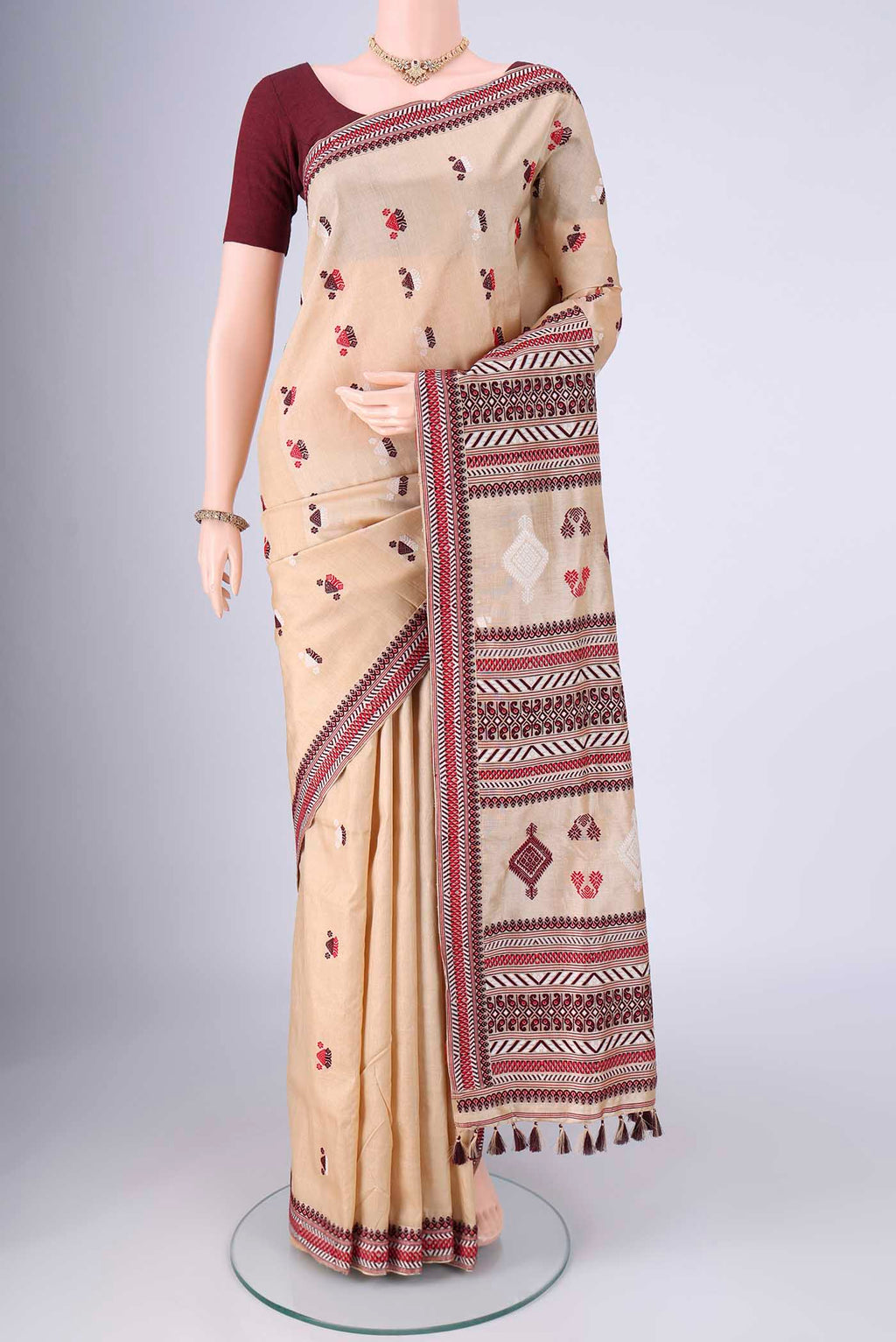 Beige Assam Silk Saree with Thread Butta on the body and Thread Border.  displayed on a mannequin