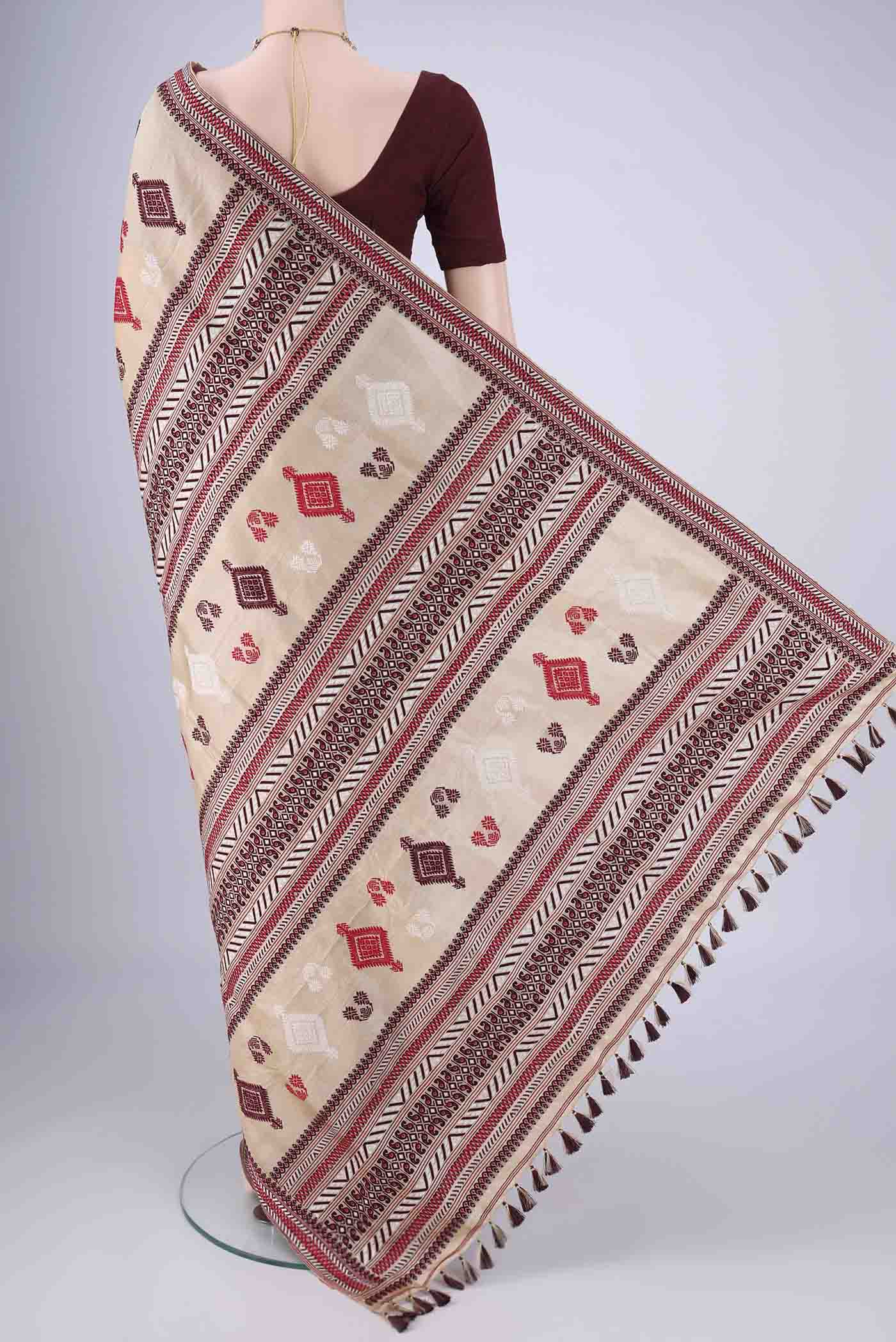 Flat view of Beige Assam Silk Saree with Thread Butta on the body and Thread Border. 