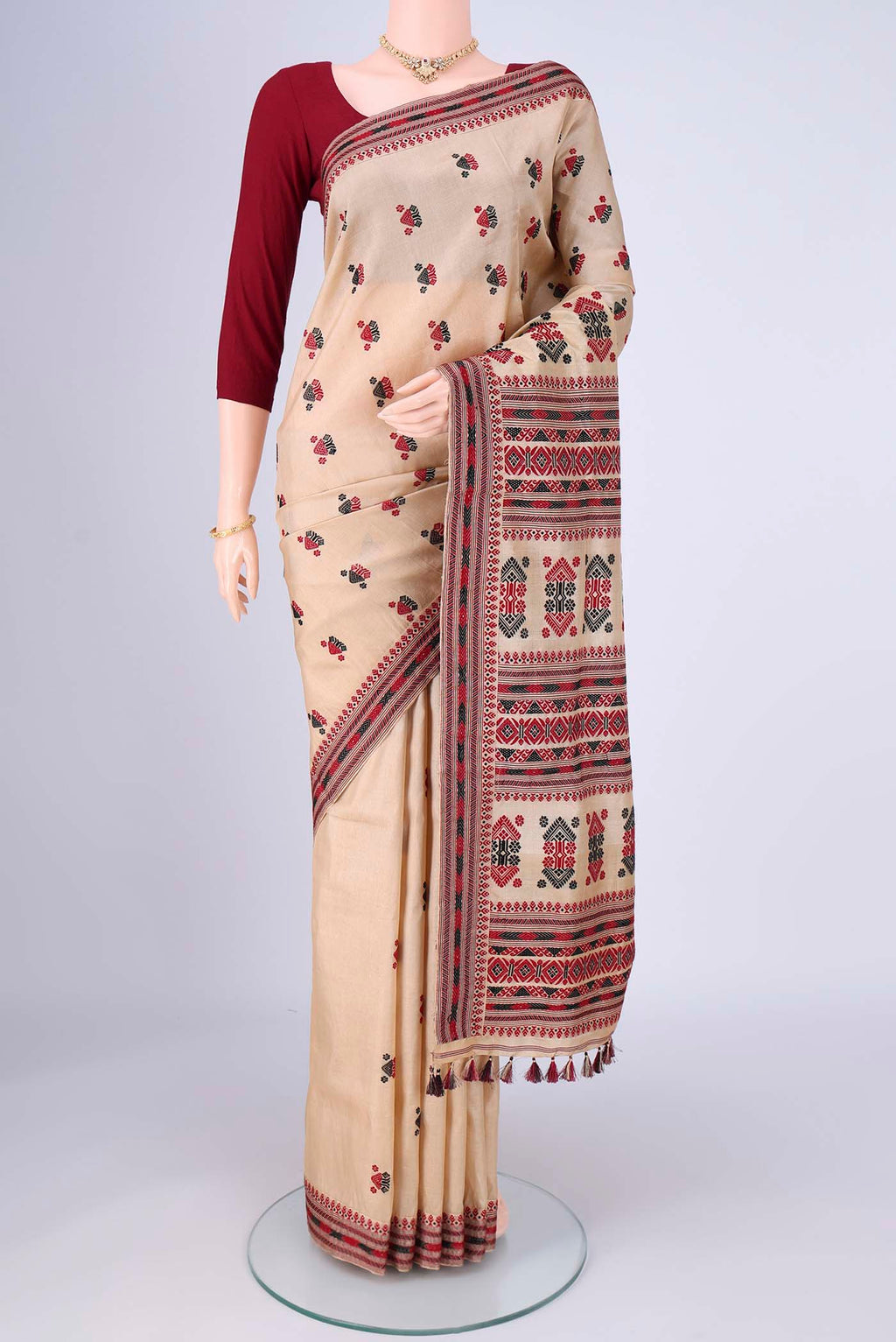 Beige Assam Silk Saree with Thread Butta on the body and Thread Border.  displayed on a mannequin