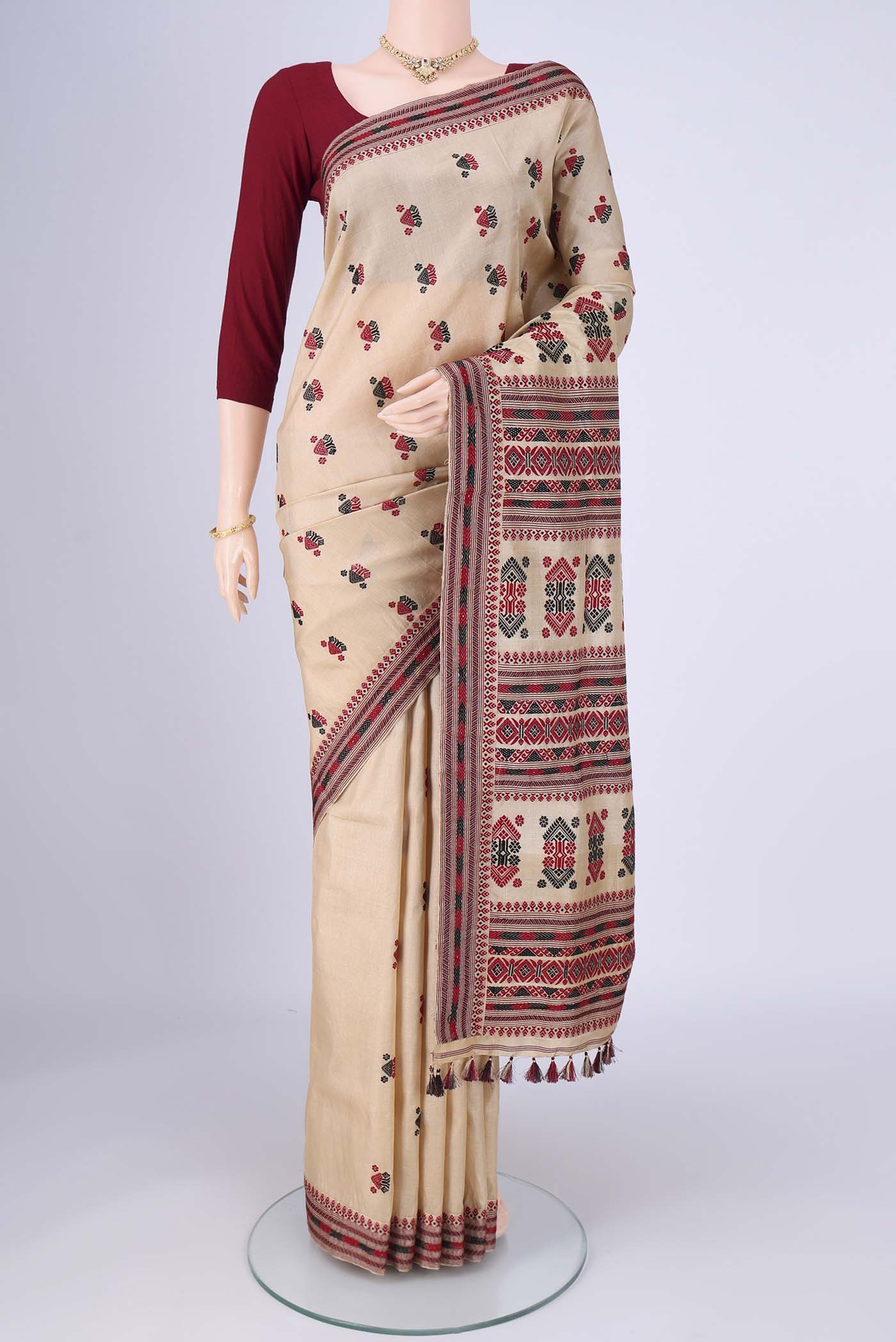 Beige Assam Silk Saree with Thread Butta on the body and Thread Border.  displayed on a mannequin