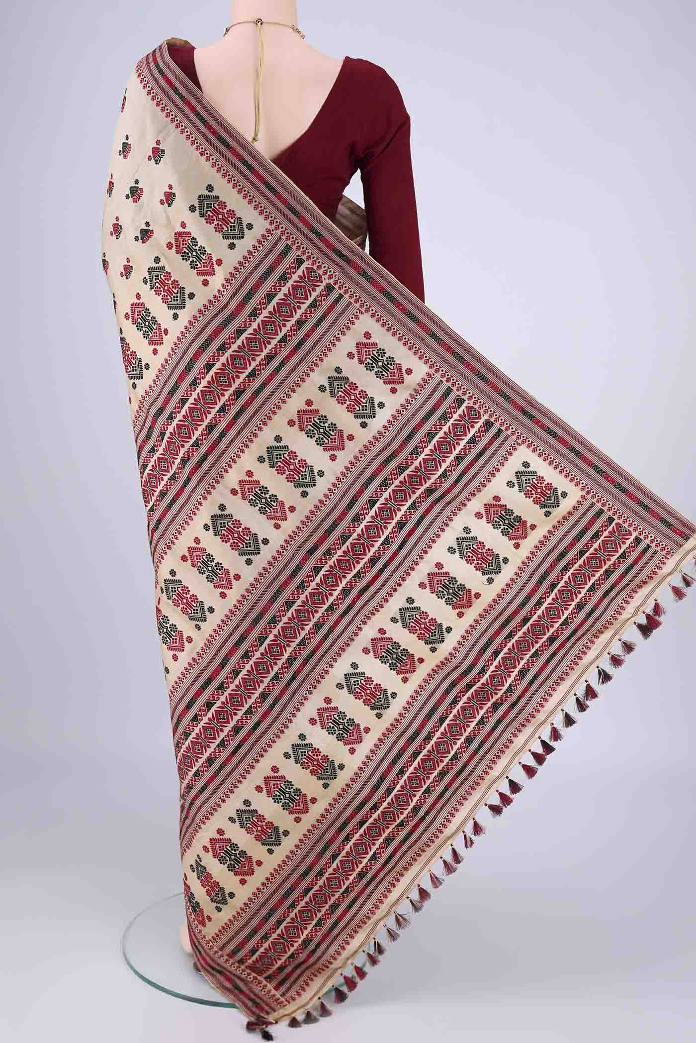 Flat view of Beige Assam Silk Saree with Thread Butta on the body and Thread Border. 
