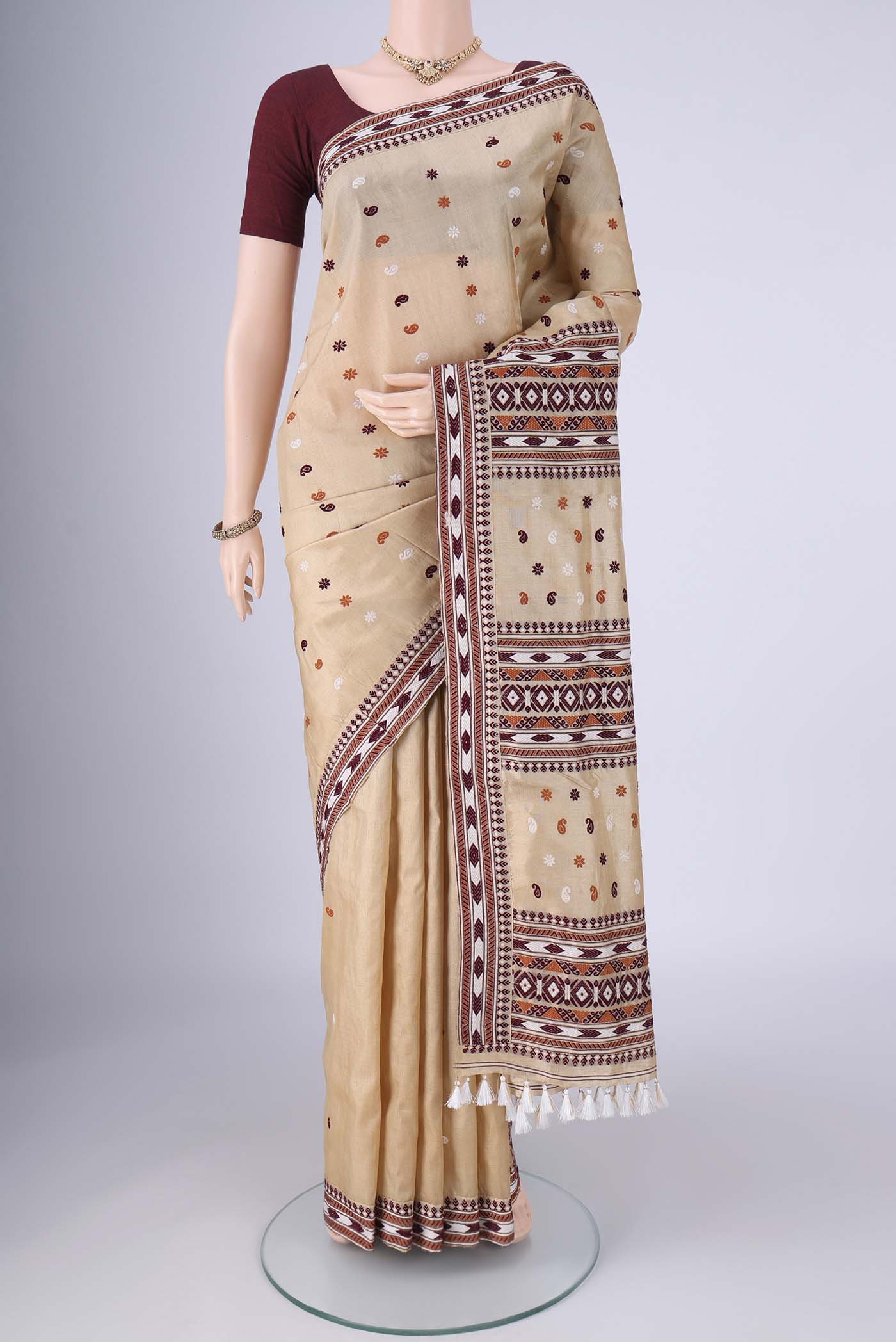 Beige Assam Silk Saree with Thread Butta on the body and Thread Border.  displayed on a mannequin