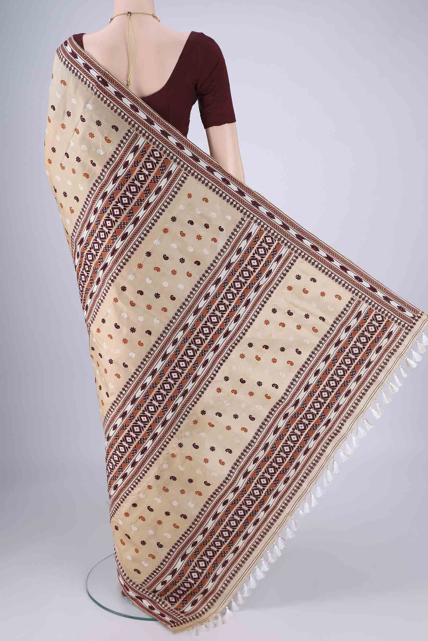 Flat view of Beige Assam Silk Saree with Thread Butta on the body and Thread Border. 