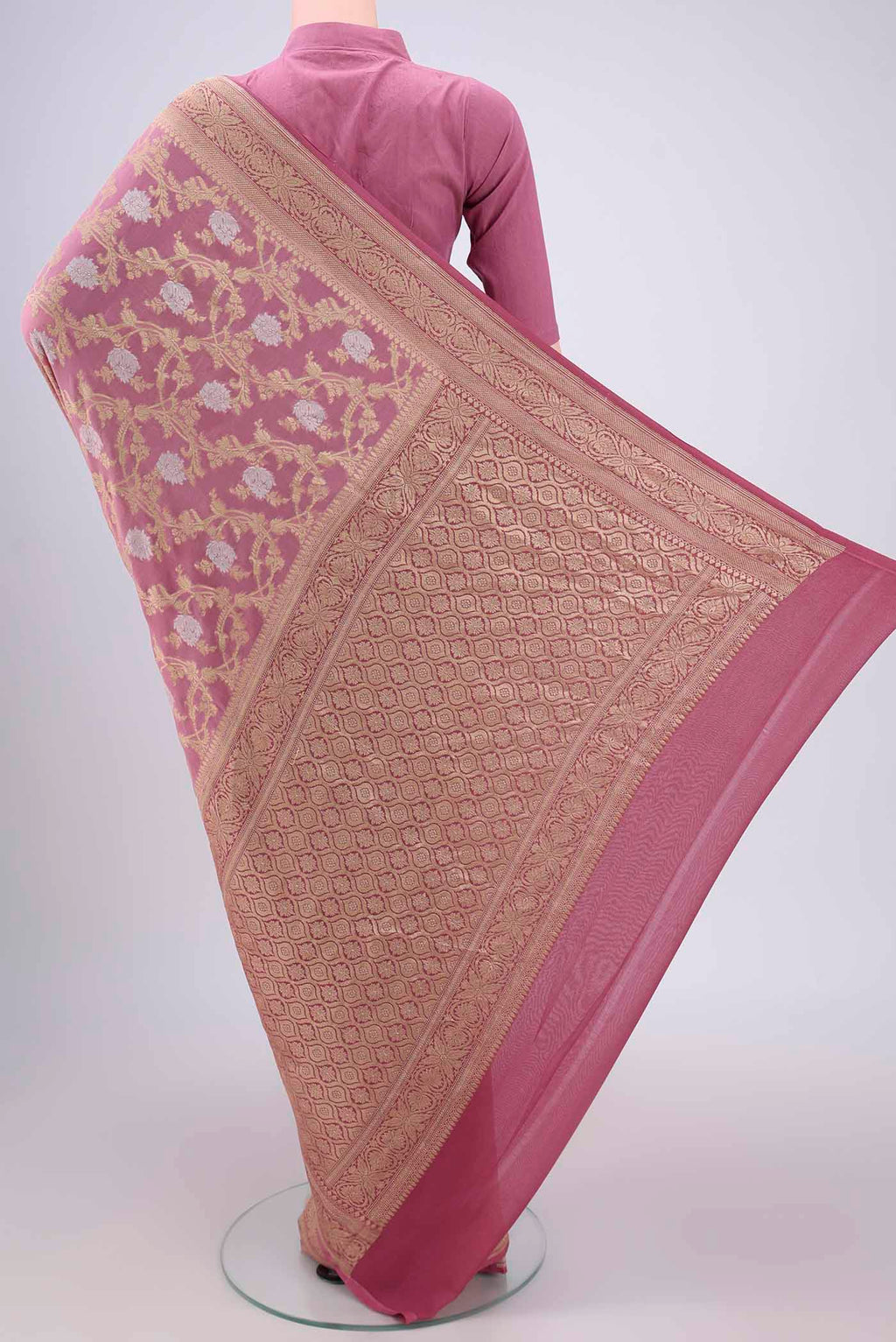 Flat view of Rose Gold Banarasi Georgette Saree with Zari Brocade on the body and Zari Border. 