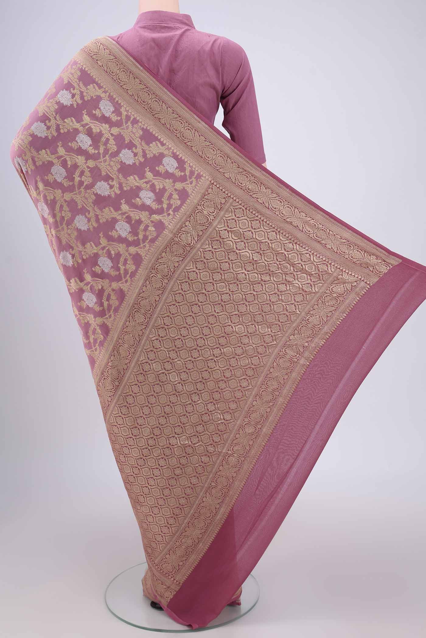 Flat view of Rose Gold Banarasi Georgette Saree with Zari Brocade on the body and Zari Border. 