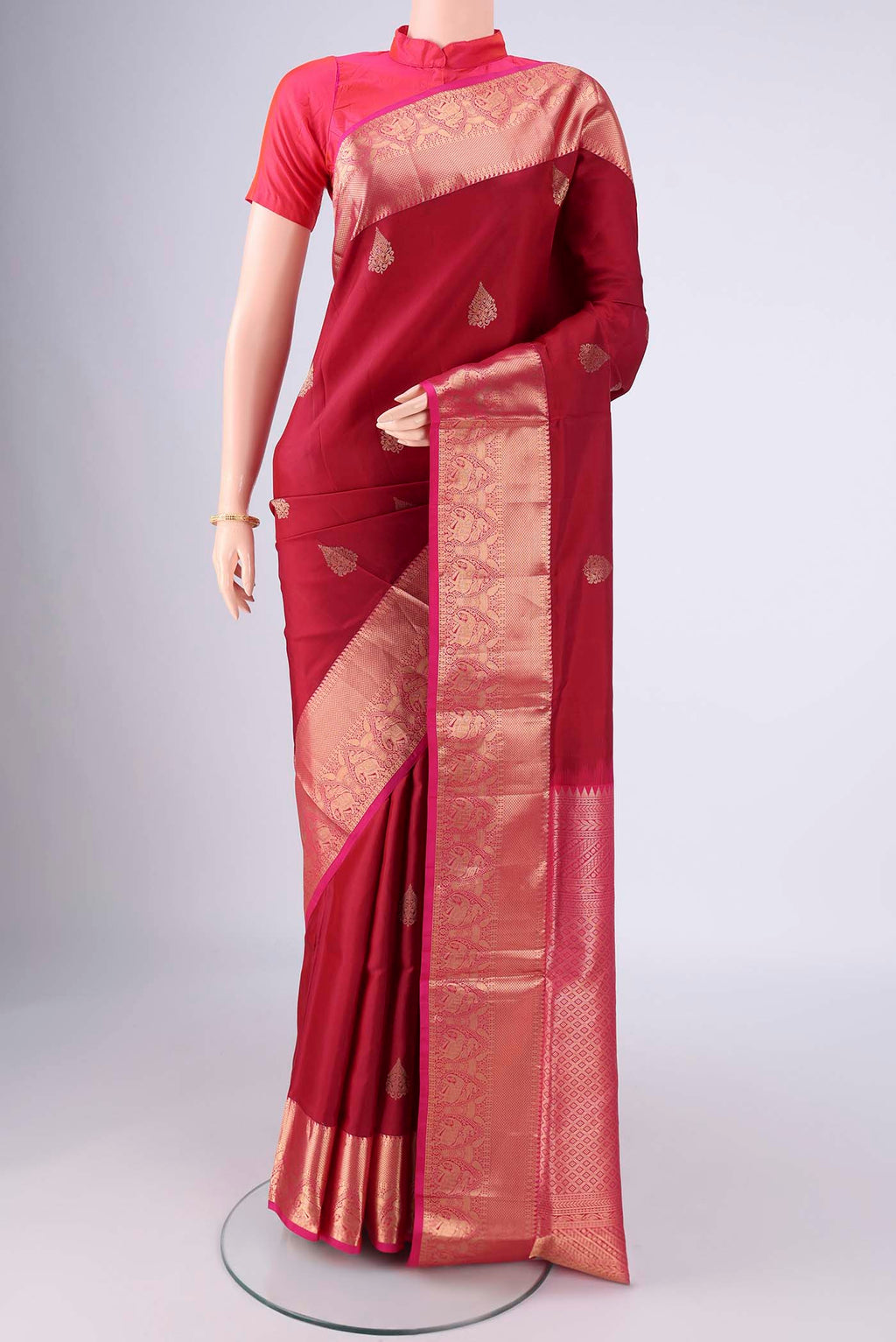 Maroon Soft Silk Saree with Zari Butta on the body and Zari Border.  displayed on a mannequin