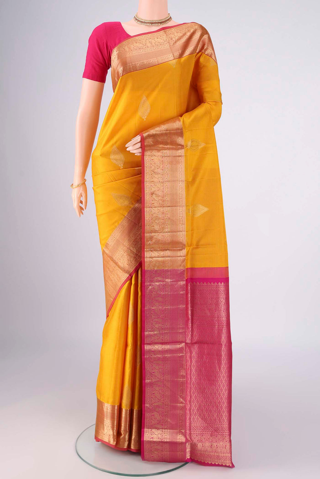 Yellow Soft Silk Saree with Zari Butta on the body and Zari Border.  displayed on a mannequin