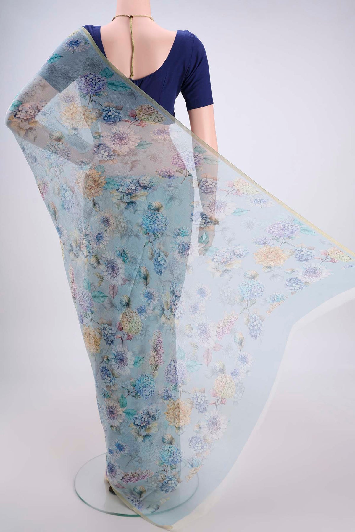 Flat view of Sky Blue Mysore Chiffon Saree with Floral Print on the body and Thin Zari Line. 