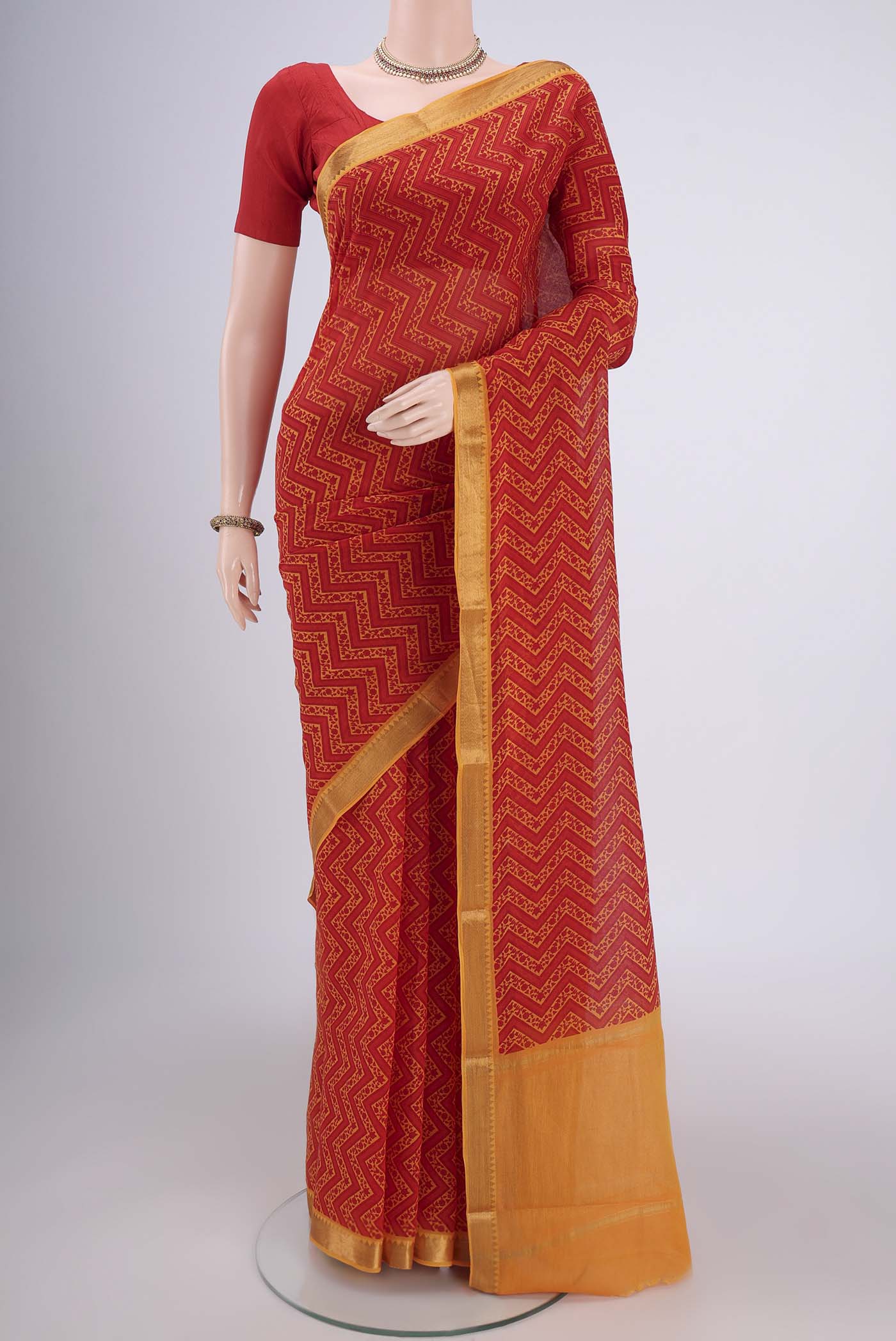 Red Mangalagiri Cotton Saree with Printed design on the body and Zari Border.  displayed on a mannequin