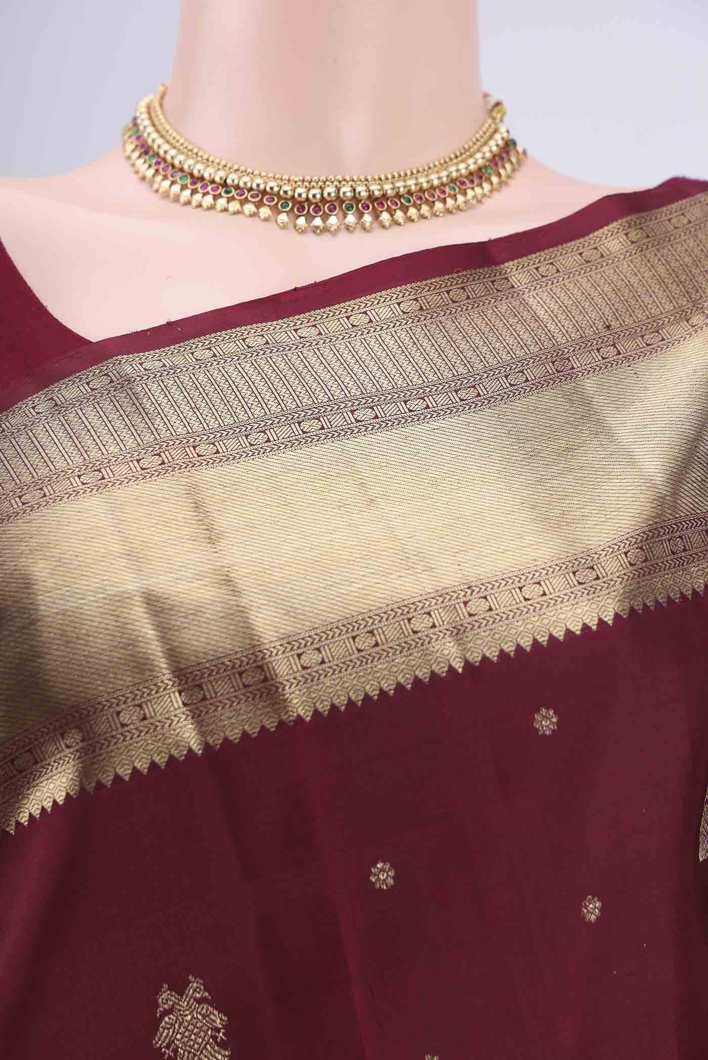 Border image of Maroon Kanjivaram Silk Saree with Zari Butta on the body and Zari Border. 