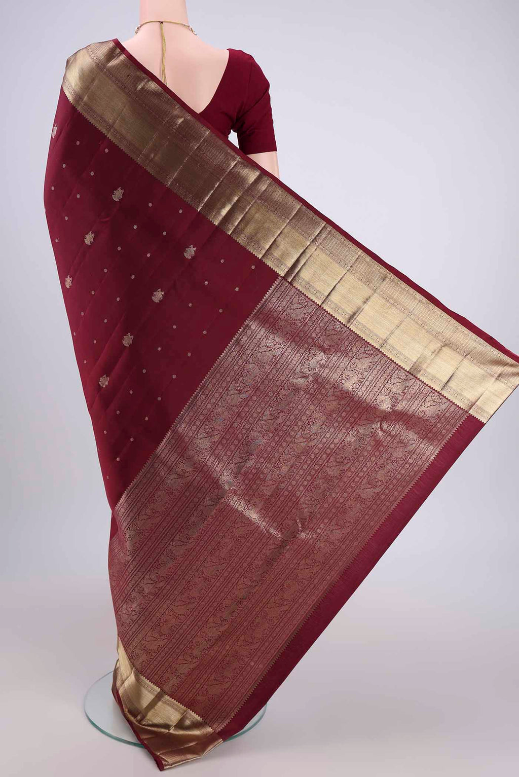 Flat view of Maroon Kanjivaram Silk Saree with Zari Butta on the body and Zari Border. 