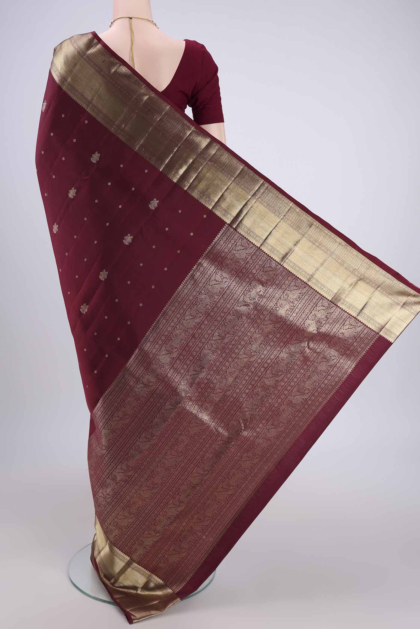 Flat view of Maroon Kanjivaram Silk Saree with Zari Butta on the body and Zari Border. 