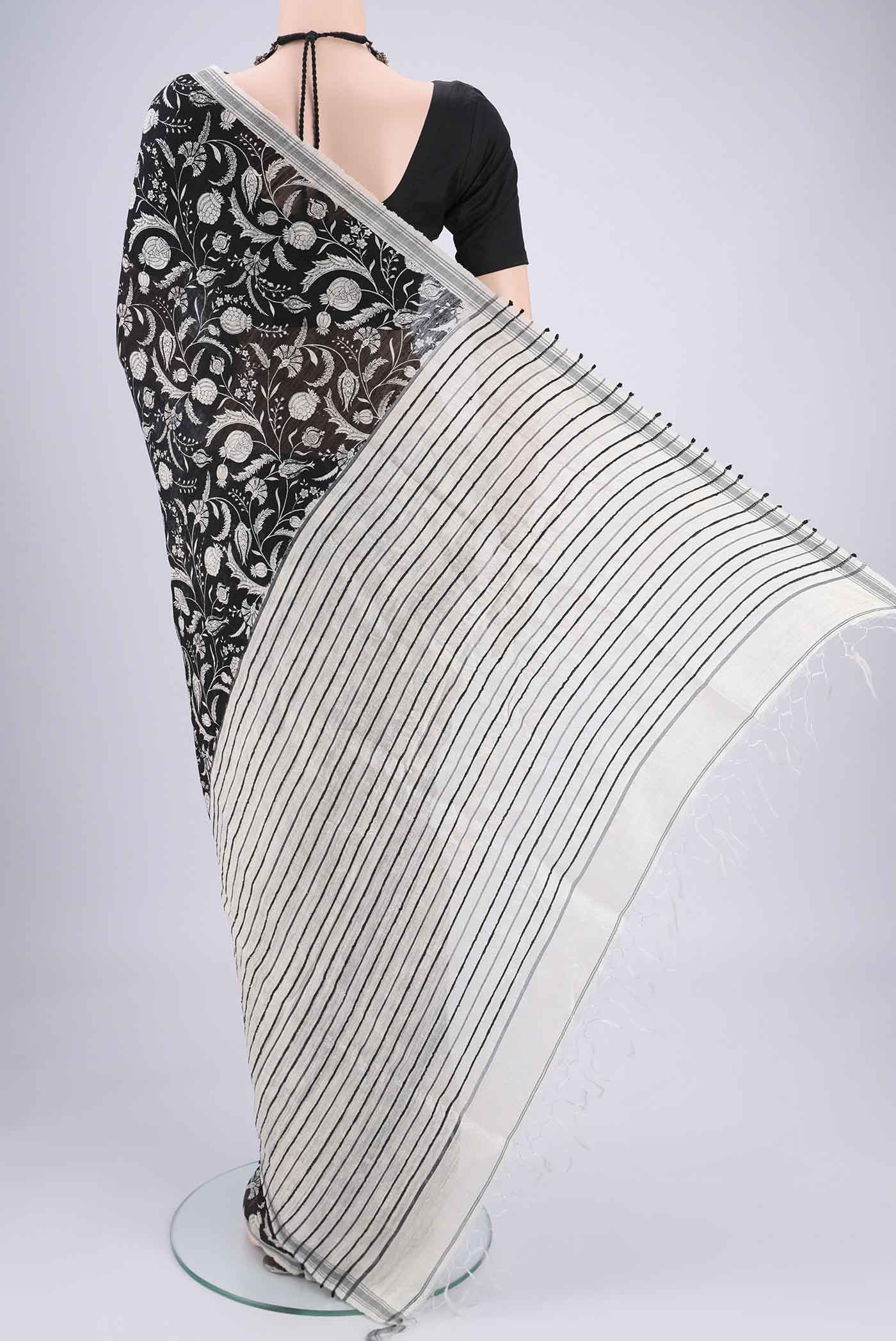Flat view of Black Tussar Silk Saree with Printed design on the body and Plain Border. 