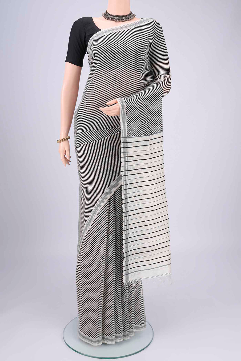 Off White Tussar Silk Saree with Stripes on the body and Plain Border.  displayed on a mannequin