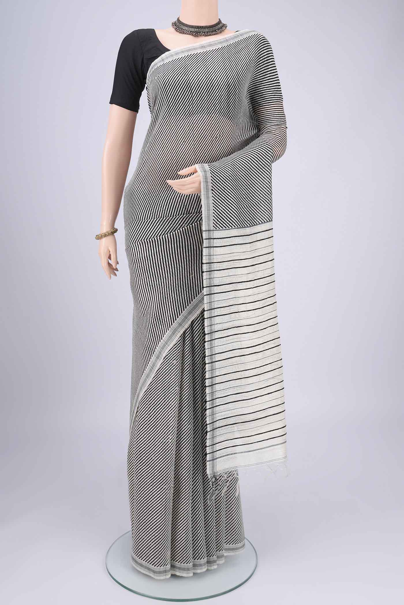 Off White Tussar Silk Saree with Stripes on the body and Plain Border.  displayed on a mannequin