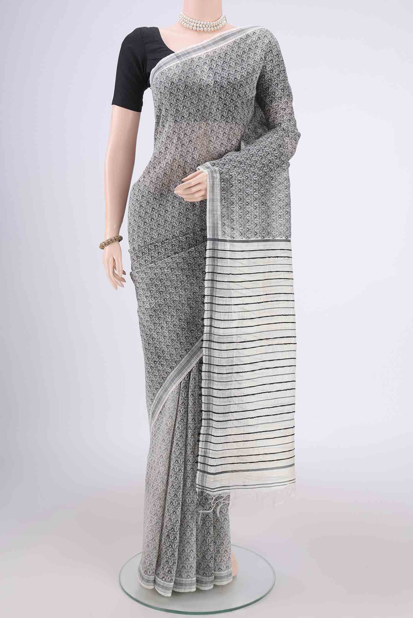 Off White Tussar Silk Saree with Printed design on the body and Plain Border.  displayed on a mannequin