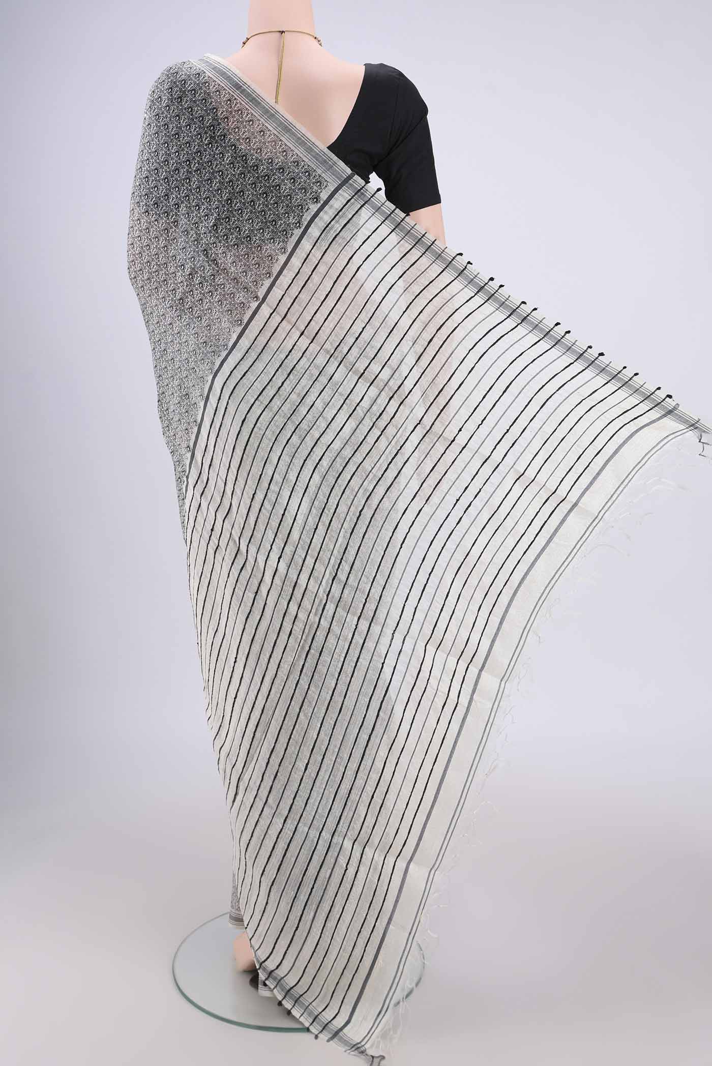 Flat view of Off White Tussar Silk Saree with Printed design on the body and Plain Border. 