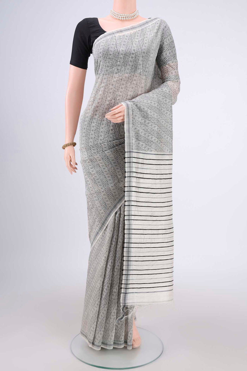 Off White Tussar Silk Saree with Printed design on the body and Plain Border.  displayed on a mannequin