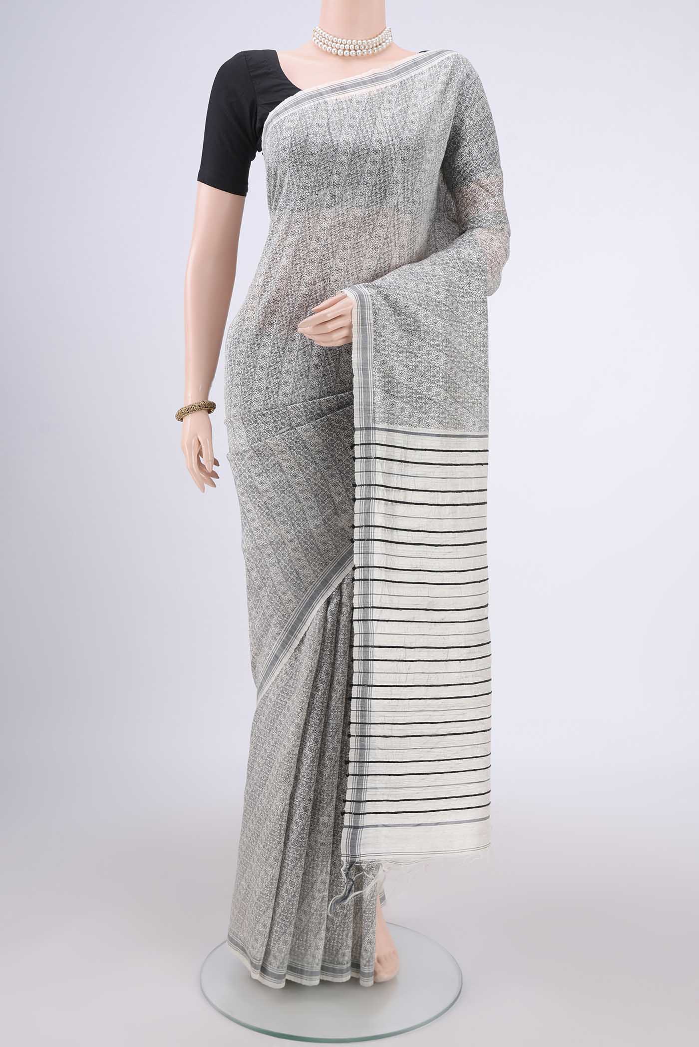 Off White Tussar Silk Saree with Printed design on the body and Plain Border.  displayed on a mannequin