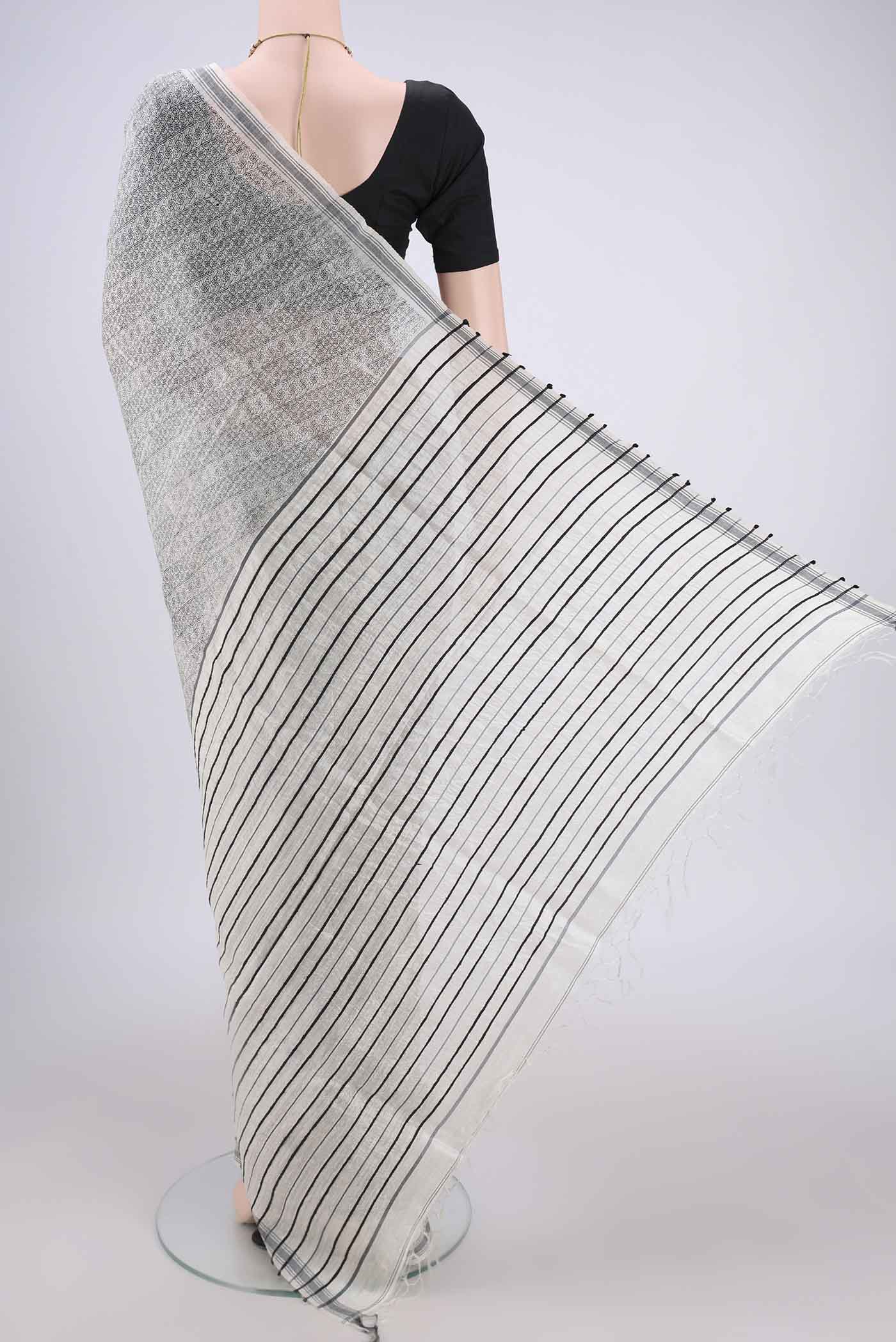 Flat view of Off White Tussar Silk Saree with Printed design on the body and Plain Border. 