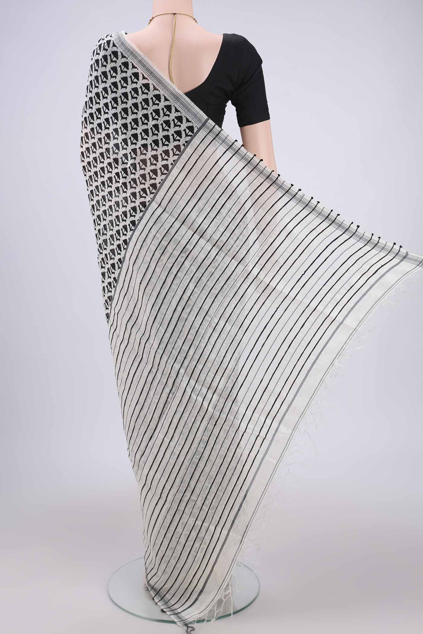 Flat view of Off White Tussar Silk Saree with Printed design on the body and Plain Border. 