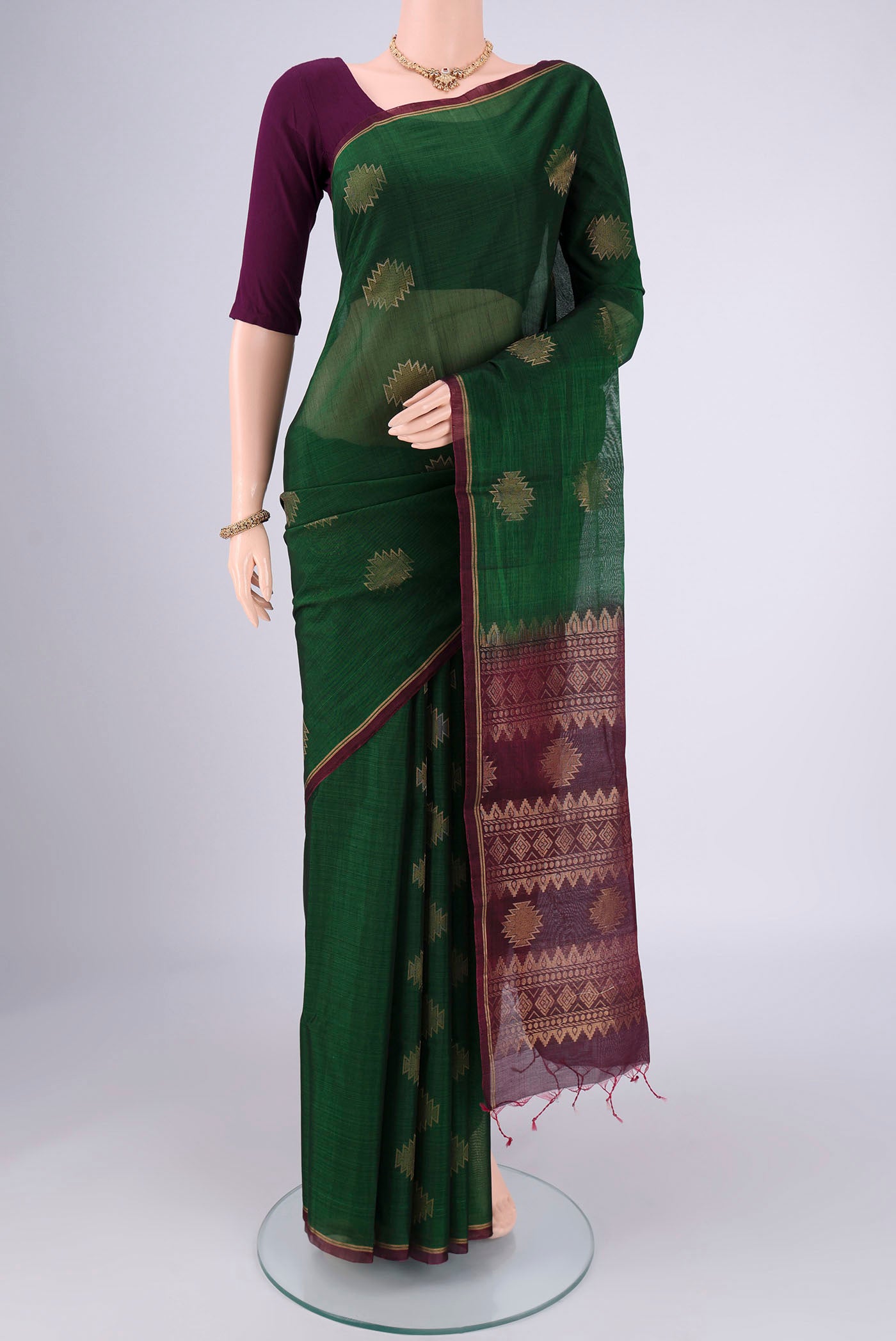 Bottle Green Silk Cotton Saree with Zari Brocade on the body and Zari Border.  displayed on a mannequin