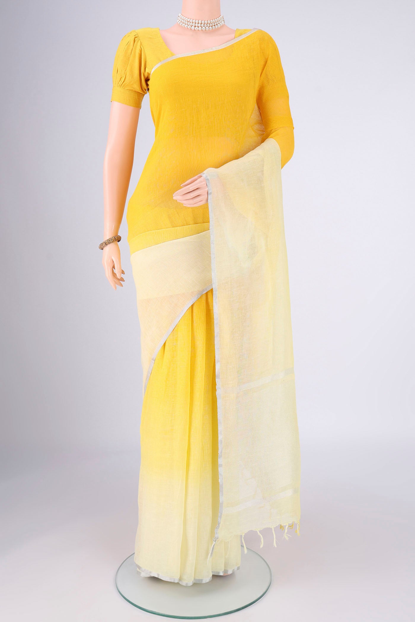 Lemon Yellow Linen Saree with Half And Half on the body and Thin Zari Line.  displayed on a mannequin