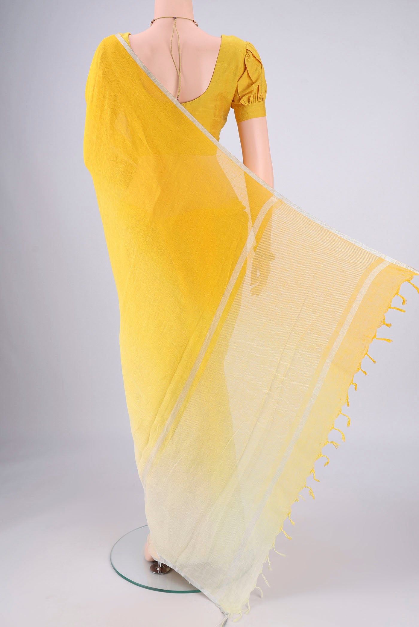 Flat view of Lemon Yellow Linen Saree with Half And Half on the body and Thin Zari Line. 