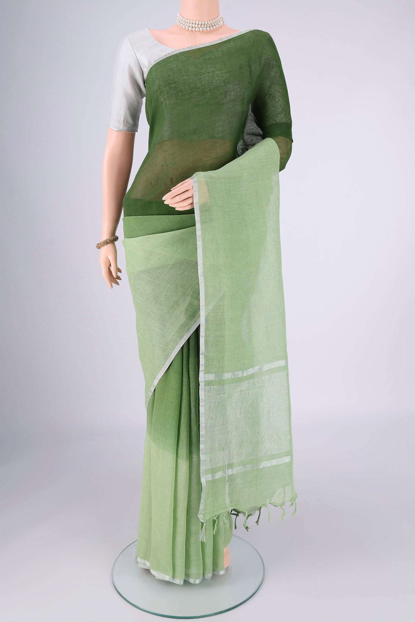 Light Green Linen Saree with Half And Half on the body and Thin Zari Line.  displayed on a mannequin