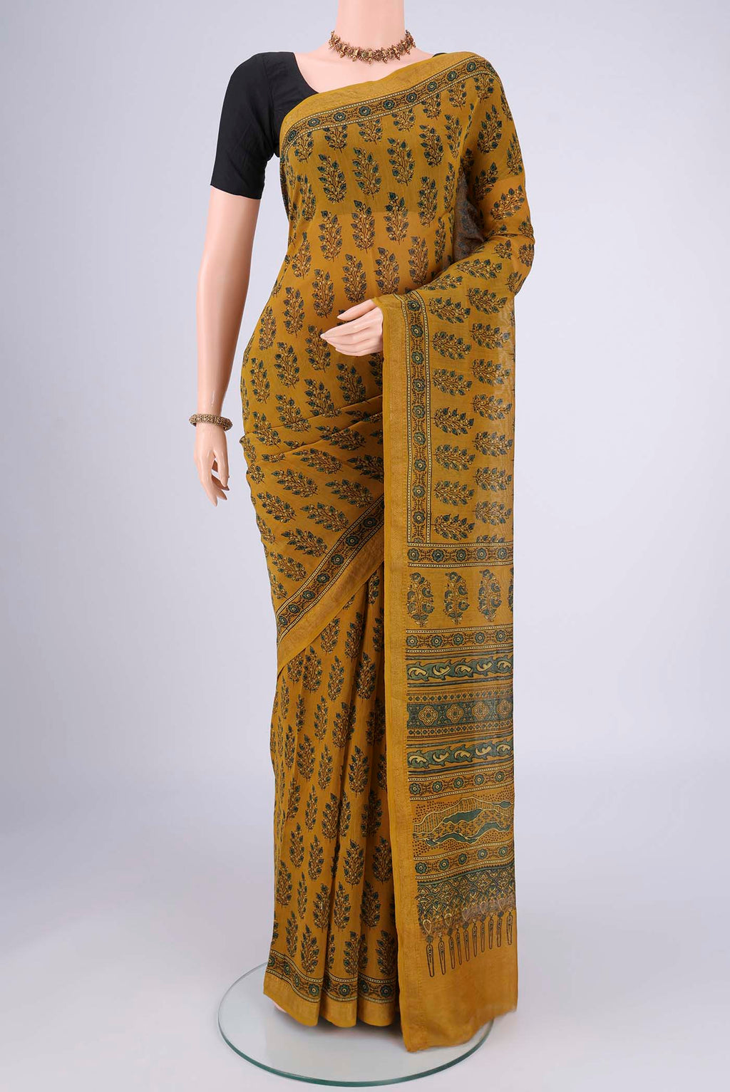 Mustard Chanderi Silk Cotton Saree with Ajrakh Print on the body and Zari Border.  displayed on a mannequin