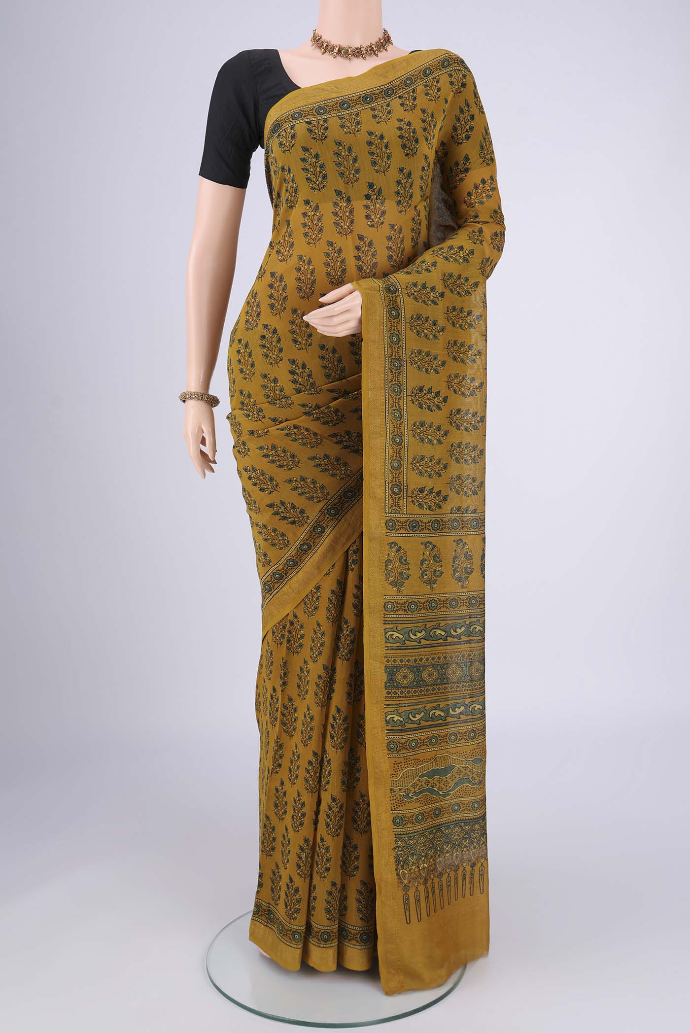 Mustard Chanderi Silk Cotton Saree with Ajrakh Print on the body and Zari Border.  displayed on a mannequin