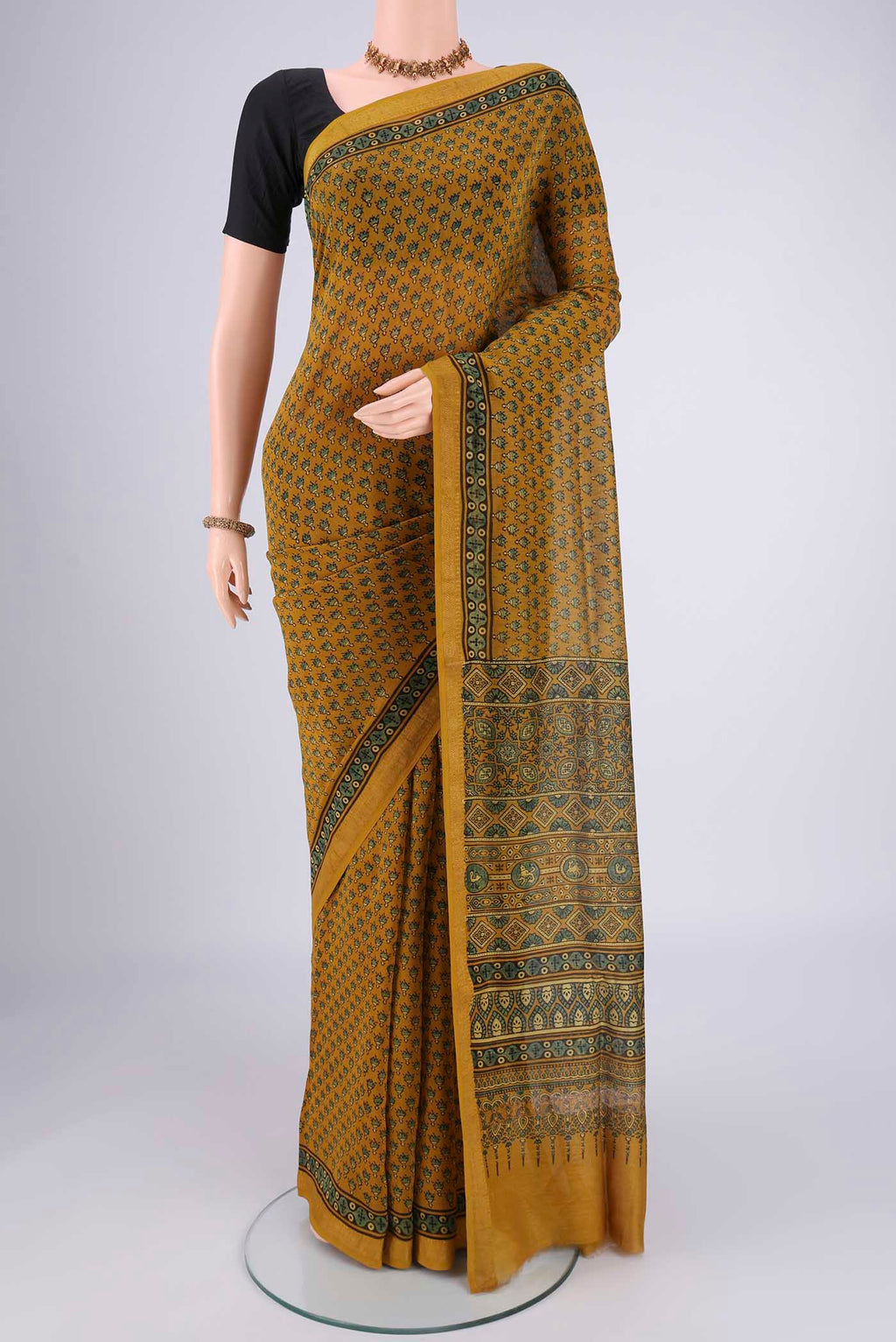 Mustard Chanderi Silk Cotton Saree with Ajrakh Print on the body and Zari Border.  displayed on a mannequin