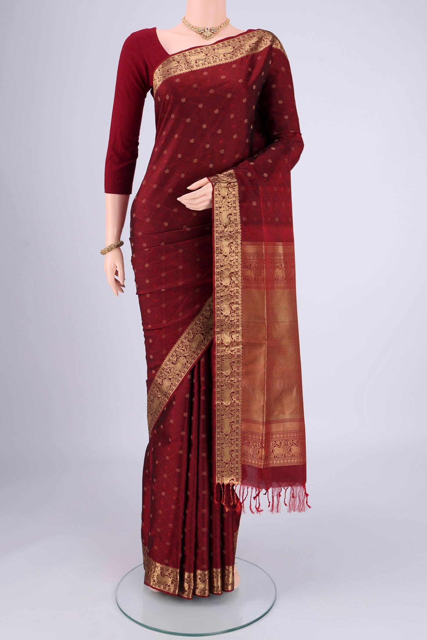 Maroon Soft Silk Saree with Jacquard With Thread Butta on the body and Zari Border.  displayed on a mannequin