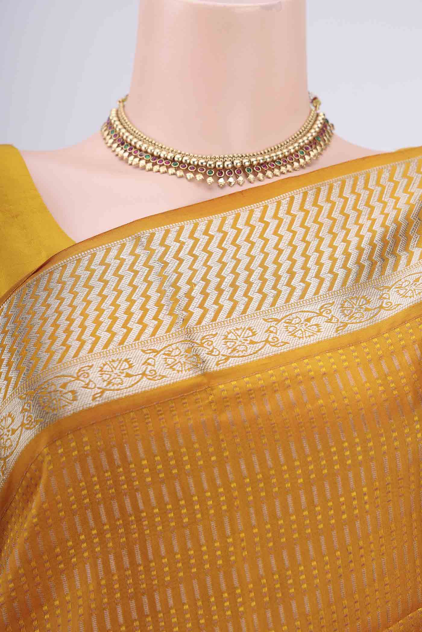 Border image of Mustard Baluchari Silk Saree with Jacquard design on the body and Zari Border. 
