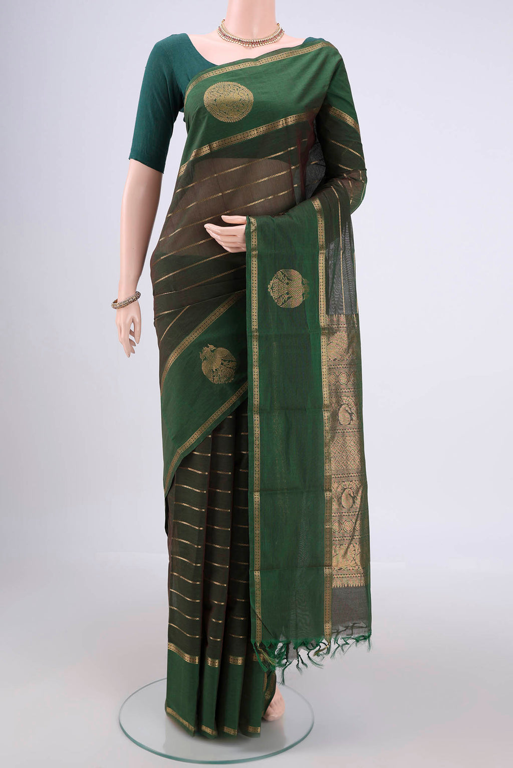 Bottle Green Kanchi Cotton Saree with Stripes on the body and Zari Border.  displayed on a mannequin