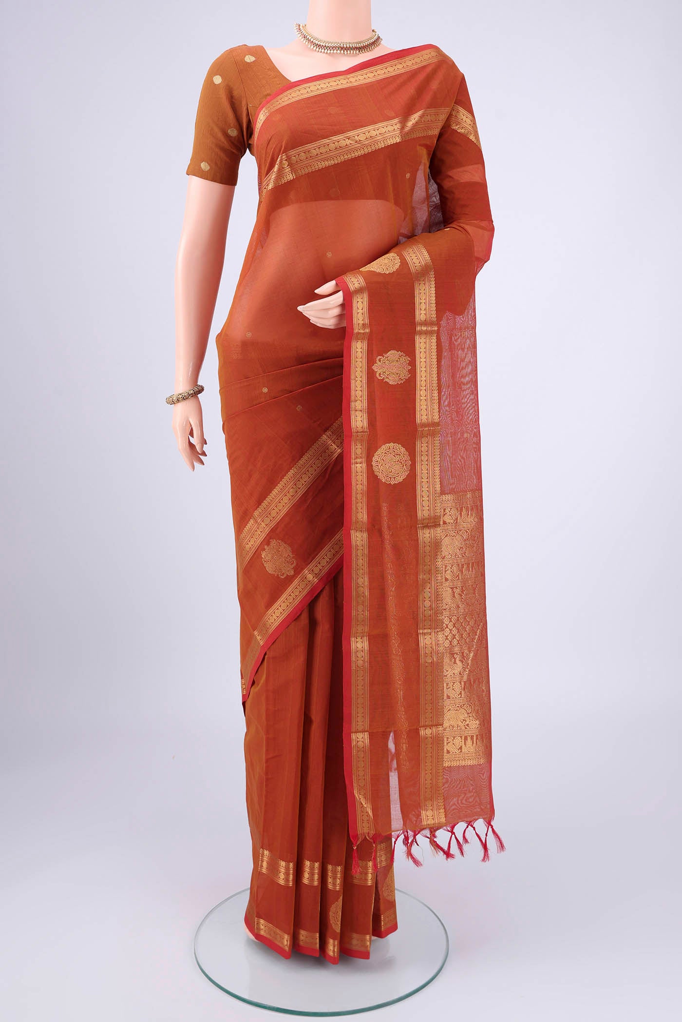 Rust Kanchi Cotton Saree with Plain Body and Zari Border.  displayed on a mannequin