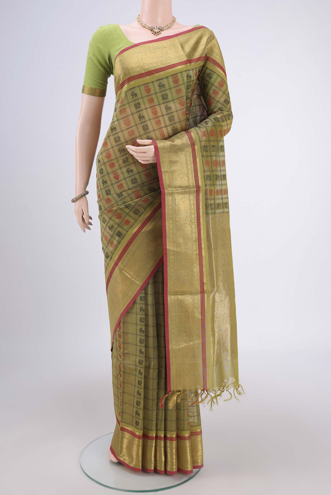 Light Green Kanjivaram Saree with Checked design on the body and Zari Border.  displayed on a mannequin
