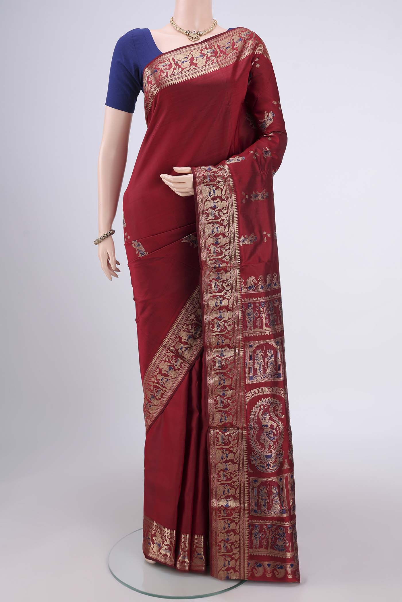 Maroon Baluchari Silk Saree with Zari And Thread Butta on the body and Zari And Thread Border.  displayed on a mannequin