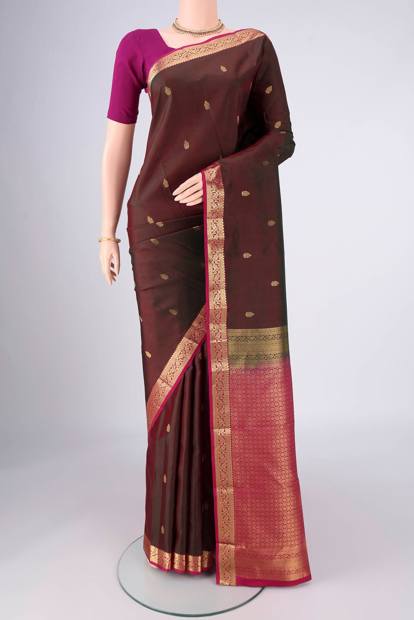 Brown Kanjivaram Silk Saree with Zari Butta on the body and Zari Border.  displayed on a mannequin