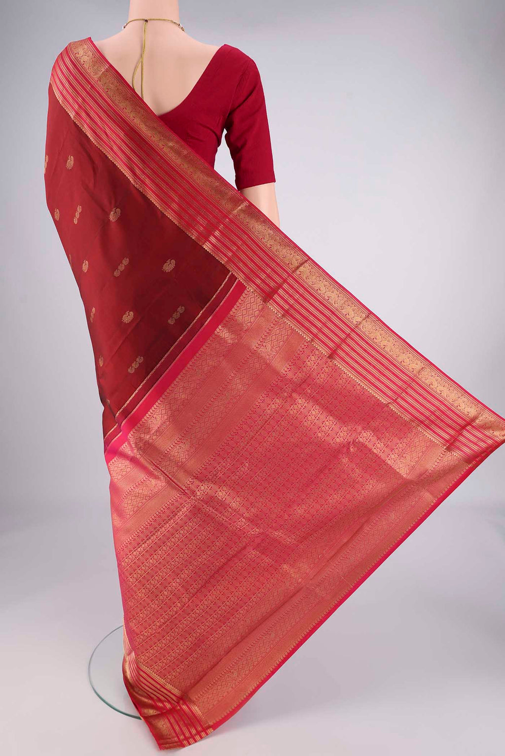 Flat view of Maroon Kanchipuram Silk Saree with Zari Butta on the body and Zari Border. 