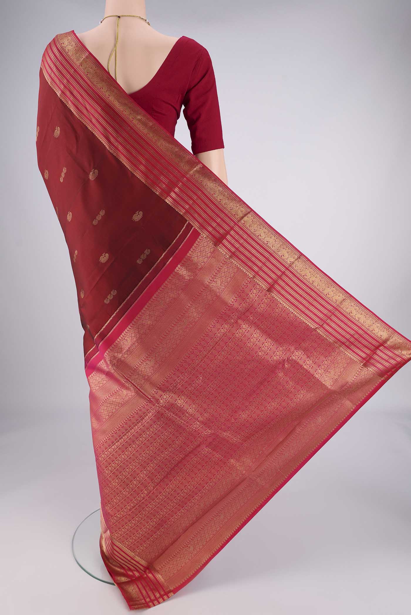 Flat view of Maroon Kanchipuram Silk Saree with Zari Butta on the body and Zari Border. 