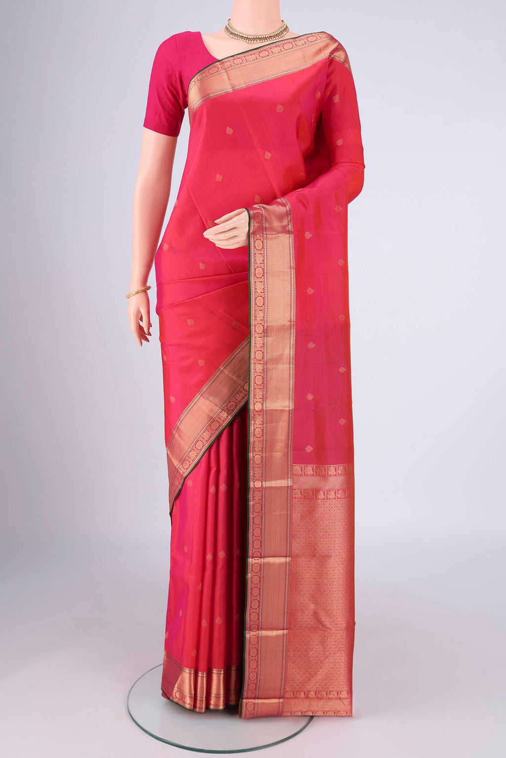 Pink Kanchipuram Silk Saree with Zari Butta on the body and Zari Border.  displayed on a mannequin