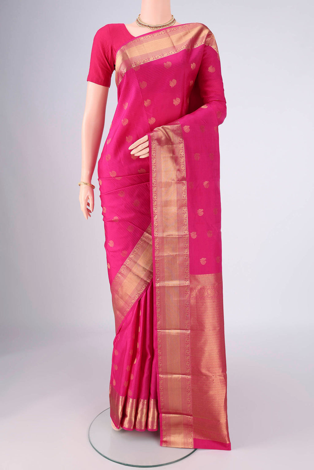 Pink Kanchipuram Silk Saree with Zari Butta on the body and Zari Border.  displayed on a mannequin