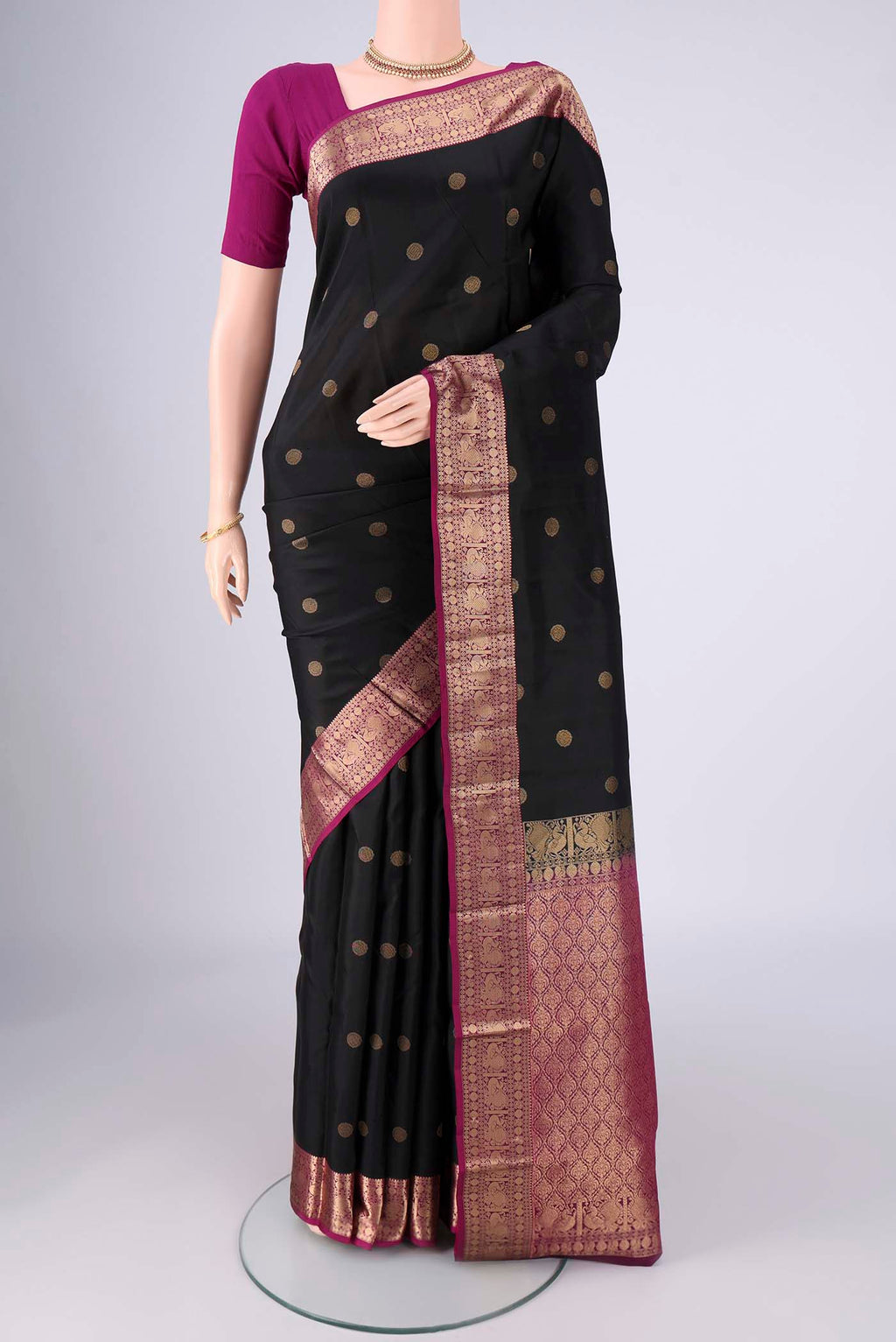 Black Kanchipuram Silk Saree with Zari Butta on the body and Zari Border.  displayed on a mannequin