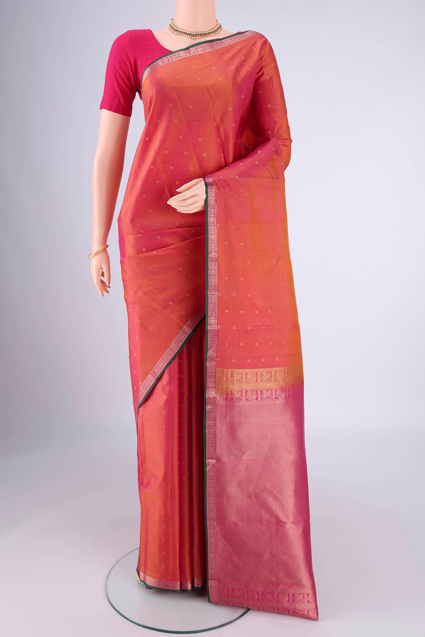 Brick Orange Dual Tone Kanjivaram Silk Saree with Zari Butta on the body and Zari Border.  displayed on a mannequin