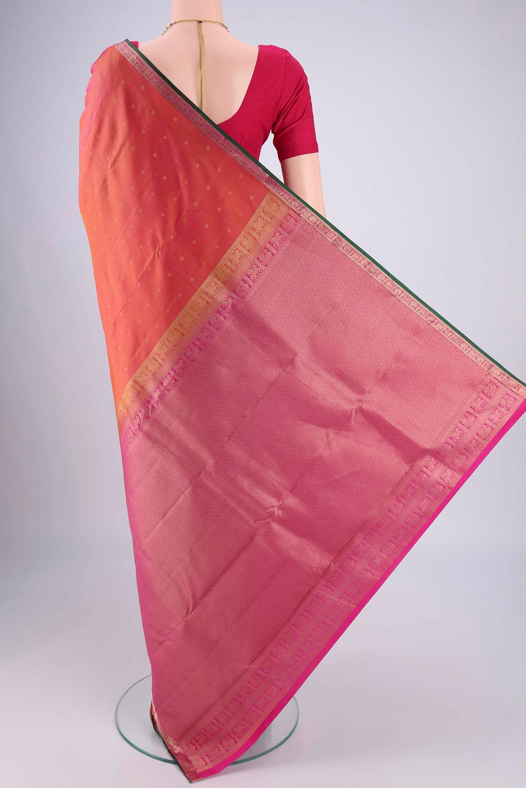 Flat view of Brick Orange Dual Tone Kanjivaram Silk Saree with Zari Butta on the body and Zari Border. 