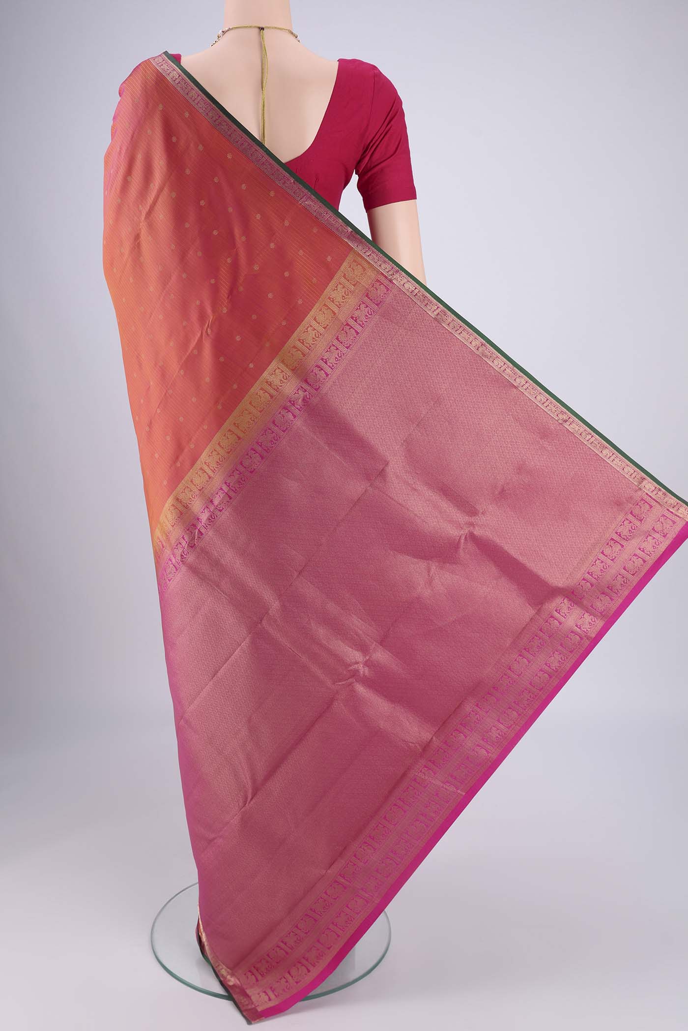 Flat view of Brick Orange Dual Tone Kanjivaram Silk Saree with Zari Butta on the body and Zari Border. 