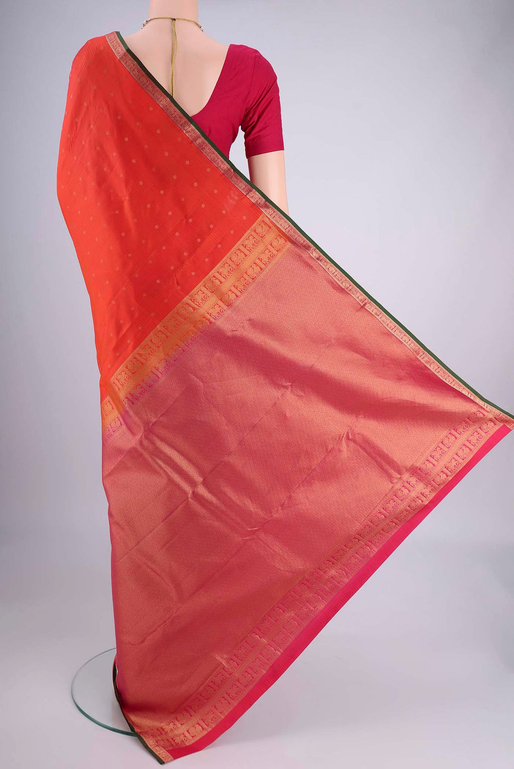 Flat view of Orange Kanjivaram Silk Saree with Zari Butta on the body and Zari Border. 